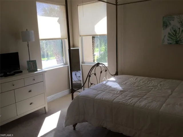 a bed sitting in a bedroom next to a window