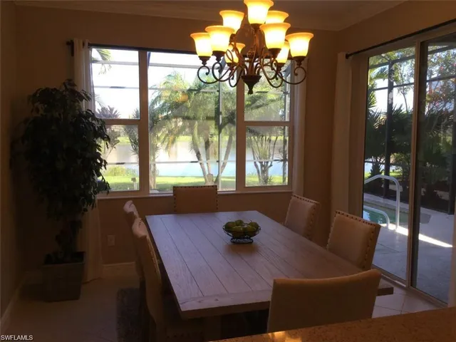 a view of a dining room with furniture a chandelier and wooden floor