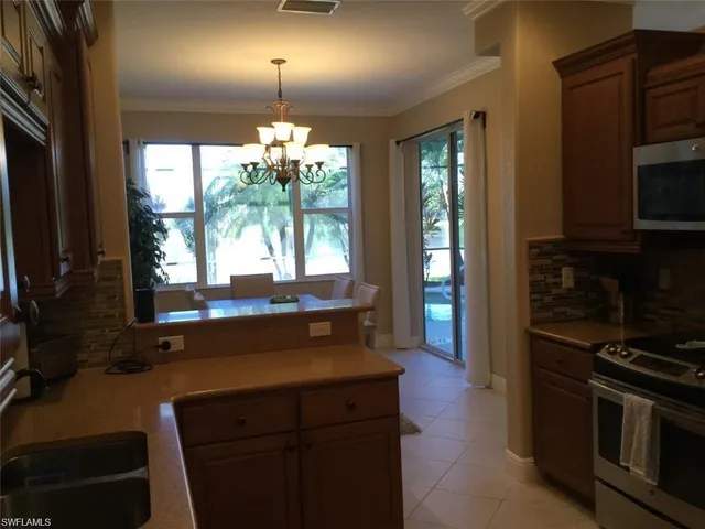 a kitchen with granite countertop a stove a sink and a microwave