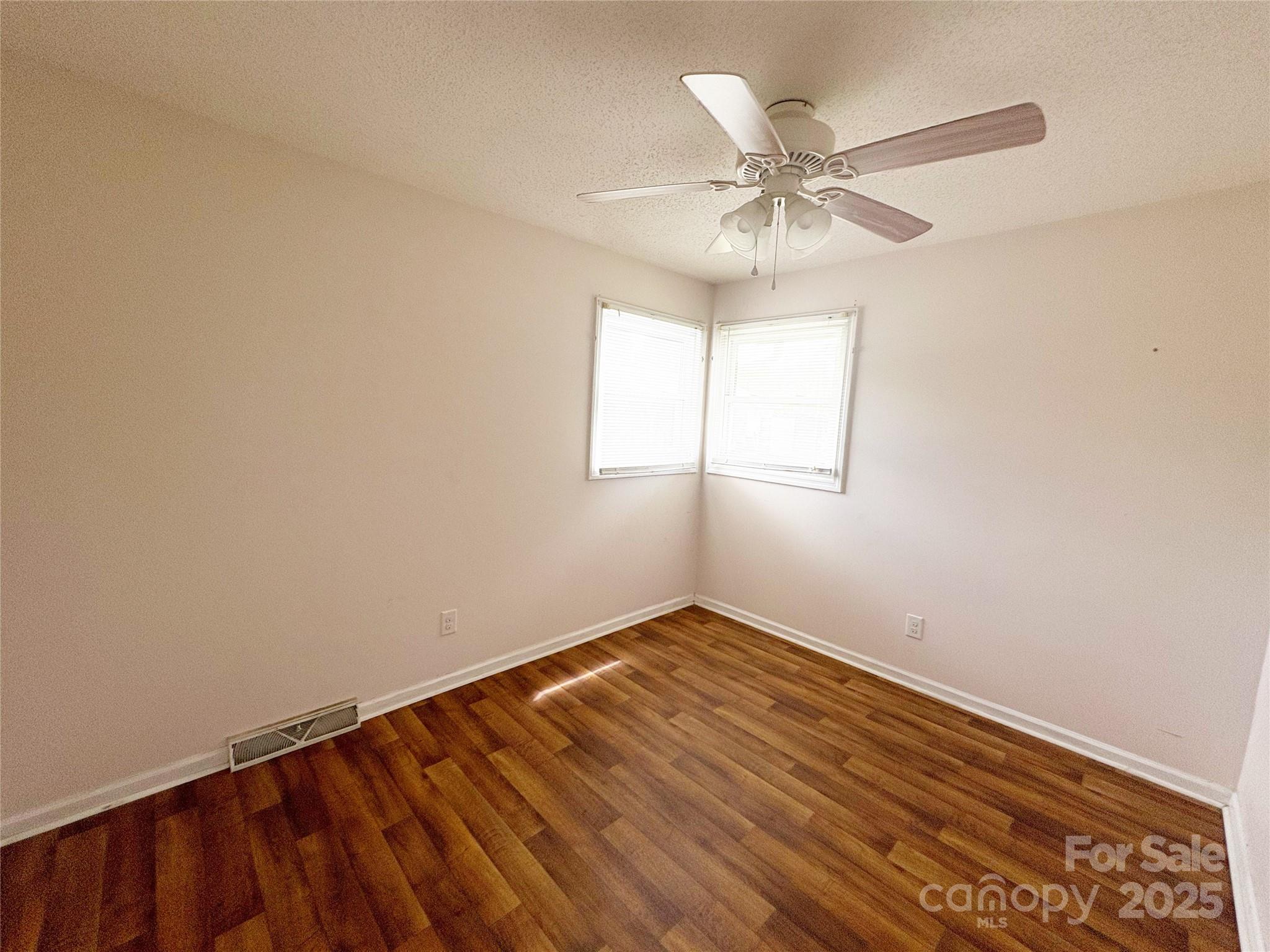 335 Plank Road Wadesboro, NC 28170 - Photo 12 of 14 an empty room with wooden floor fan and windows