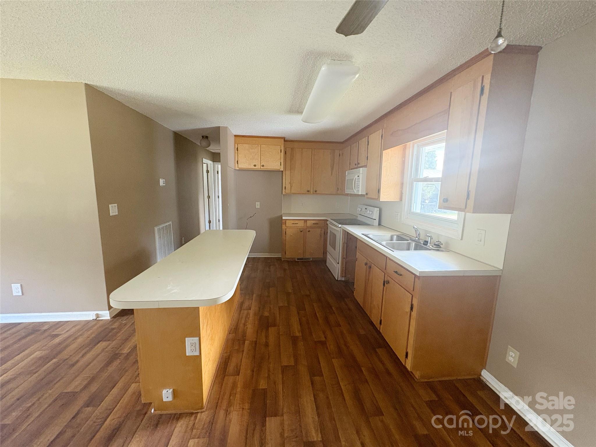 335 Plank Road Wadesboro, NC 28170 - Photo 7 of 14 a kitchen with a sink and wooden floor