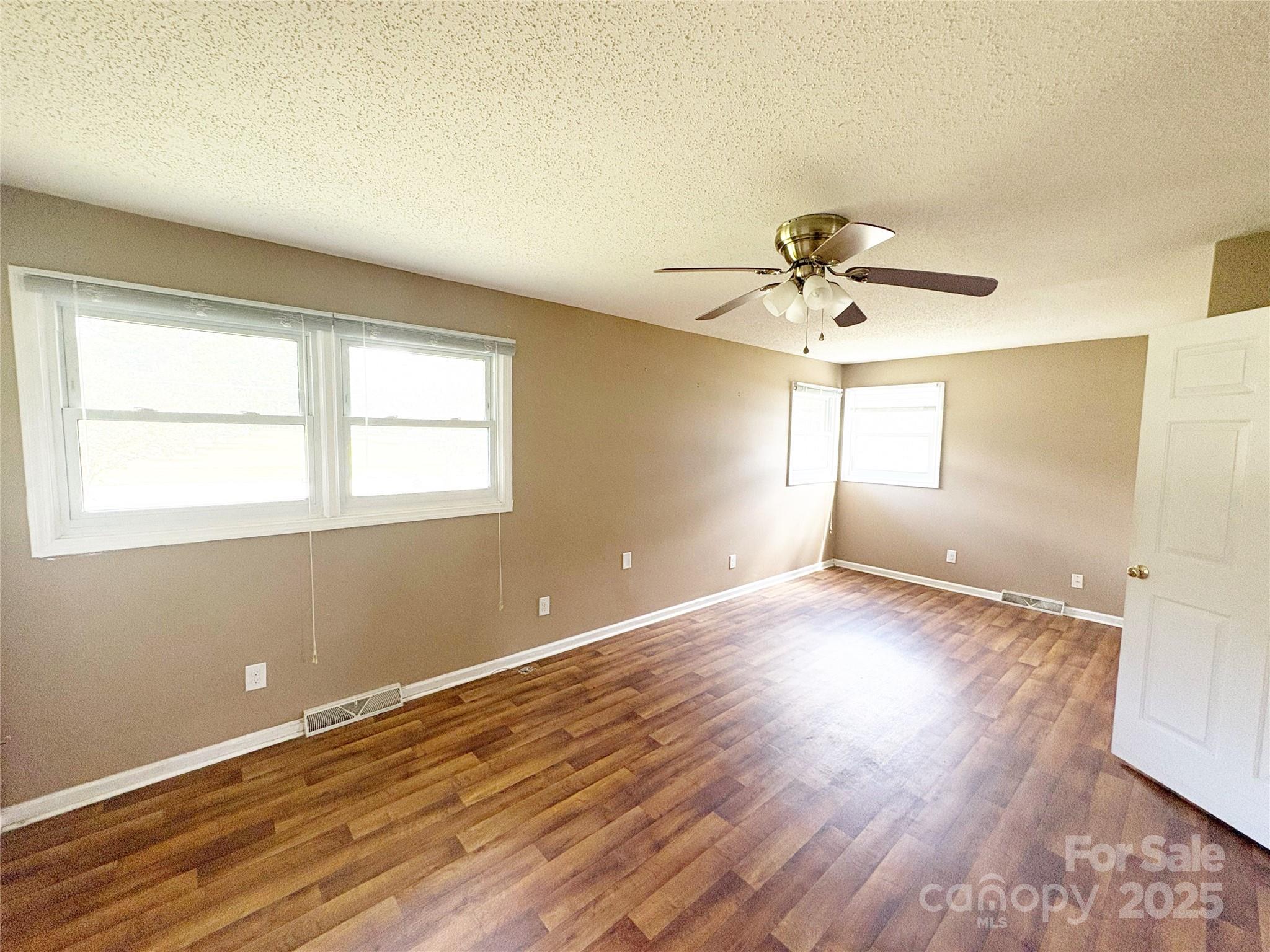 335 Plank Road Wadesboro, NC 28170 - Photo 10 of 14 an empty room with wooden floor and windows