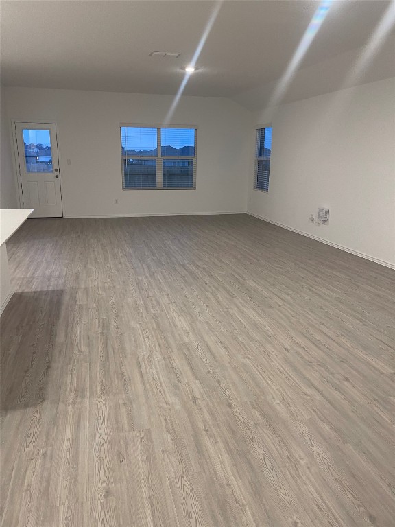 169 Sormonne Loop Kyle, TX 78640 - Photo 7 of 11 an empty room with wooden floor and windows