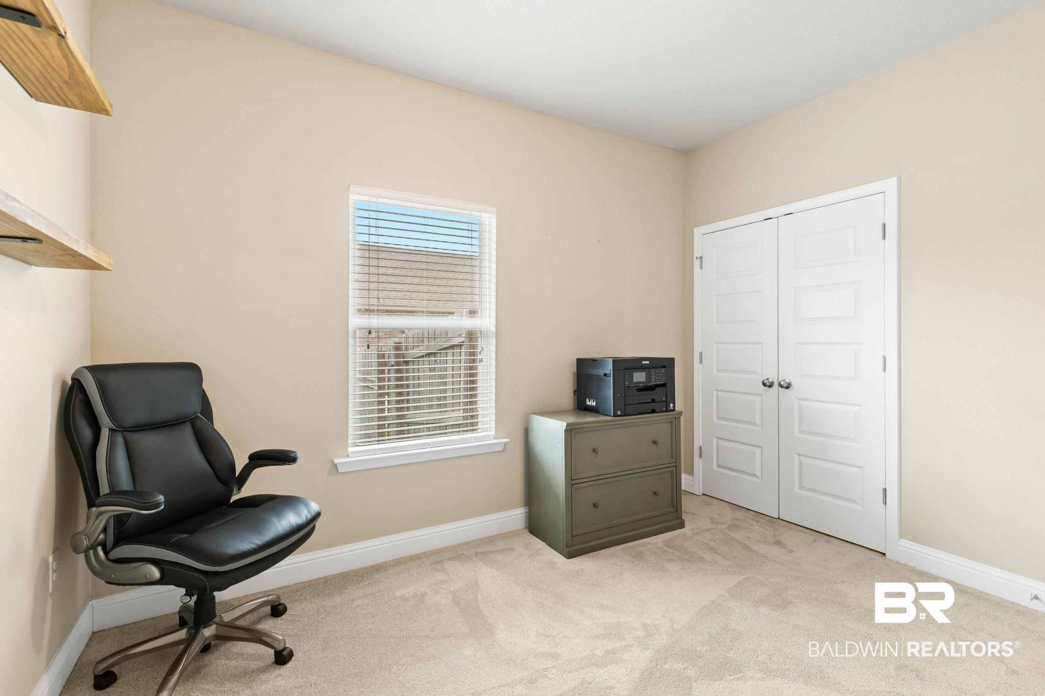 31187 Spoonbill Road Daphne, AL 36527 - Photo 39 of 85 Neutral-toned room featuring a single window with blinds, light-colored carpeting, white baseboards, and a pair of white paneled bifold doors