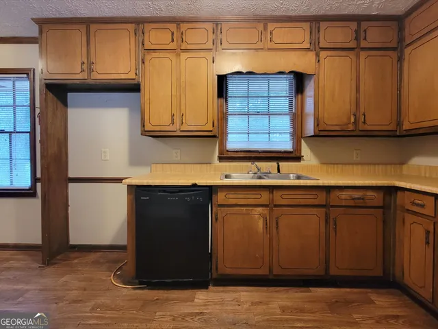 an empty room with chandelier fan and windows