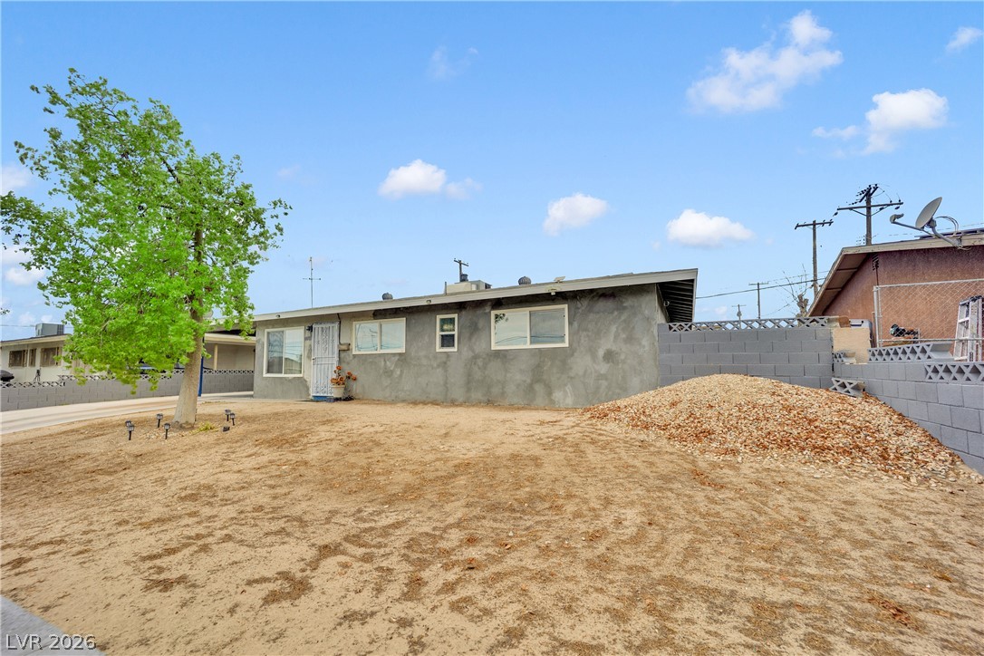 2221 Englestad Street North Las Vegas, NV 89030 - Photo 2 of 32 A single-story residence with a stucco exterior and mature tree, offering a blank canvas for landscaping dreams.