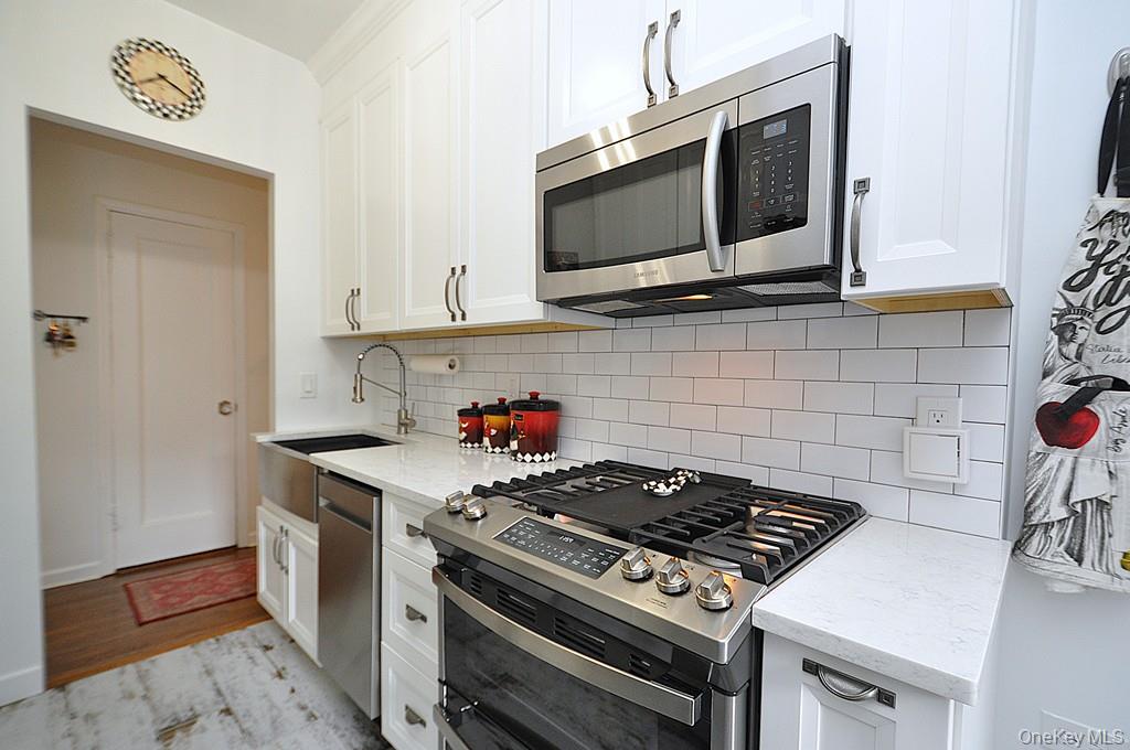 143 Garth Road, Unit 3L Scarsdale, NY 10583 - Photo 13 of 50 a kitchen with a stove and a microwave