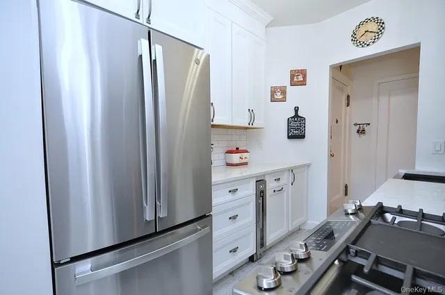 a kitchen with stainless steel appliances granite countertop a refrigerator and a stove