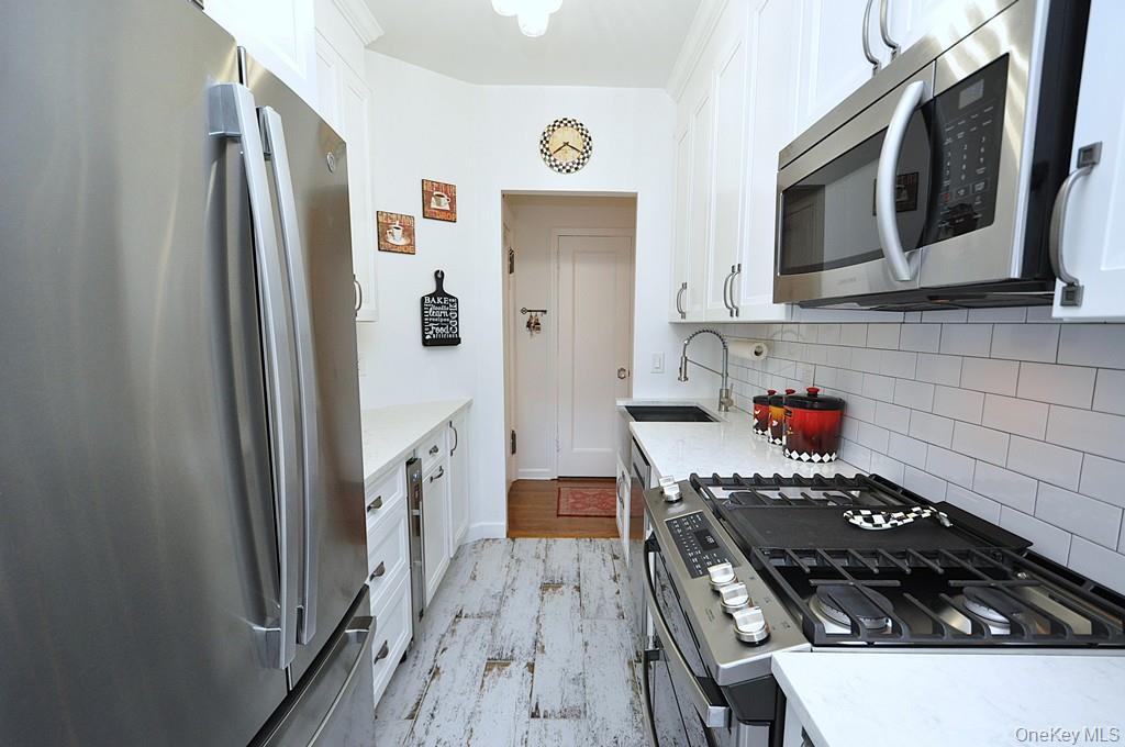 143 Garth Road, Unit 3L Scarsdale, NY 10583 - Photo 16 of 50 a kitchen with stainless steel appliances granite countertop a refrigerator and a stove