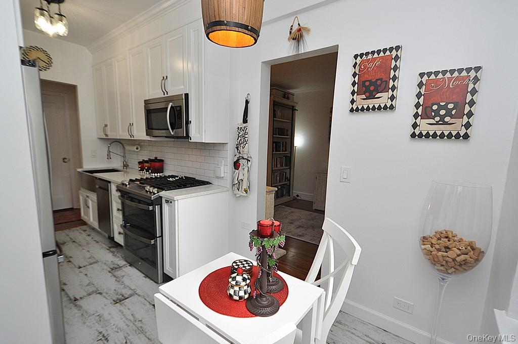 143 Garth Road, Unit 3L Scarsdale, NY 10583 - Photo 20 of 50 a kitchen with stainless steel appliances a stove a microwave and a table