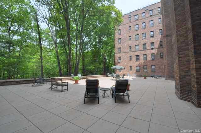 143 Garth Road, Unit 3L Scarsdale, NY 10583 - Photo 39 of 50 a view of a patio with dining table and chairs with a fire pit and a chair