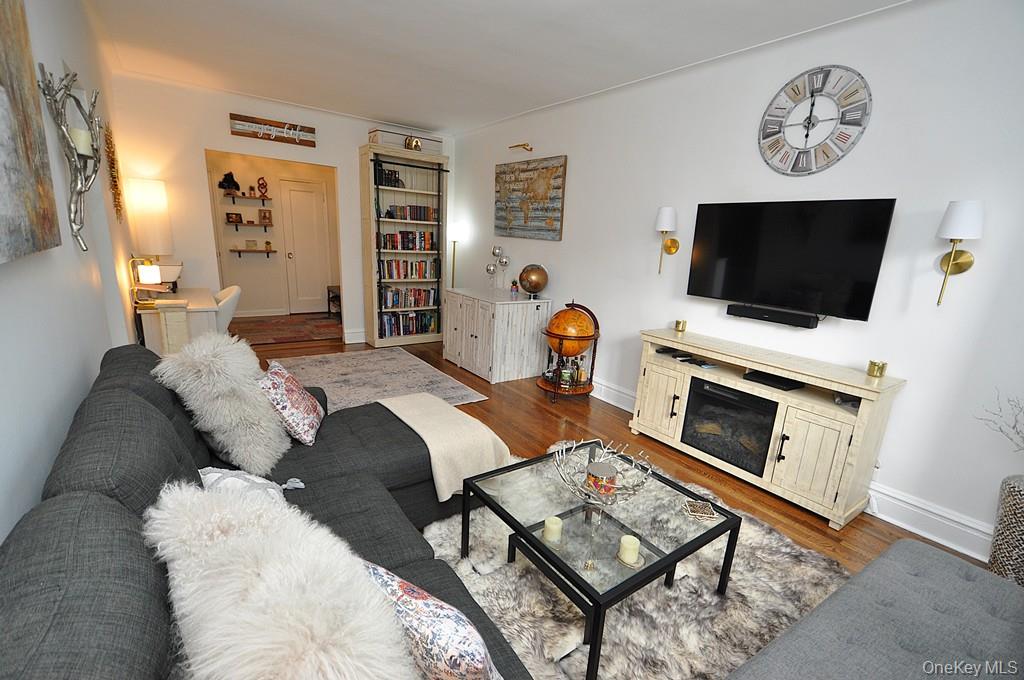 143 Garth Road, Unit 3L Scarsdale, NY 10583 - Photo 6 of 50 a living room with furniture a flat screen tv and a fireplace