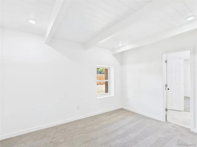 an empty room with wooden floor and window