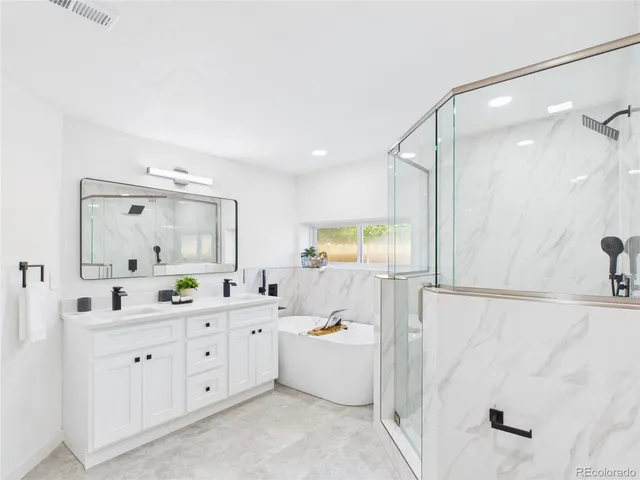 a large bathroom with a double vanity sink a mirror and a bathtub