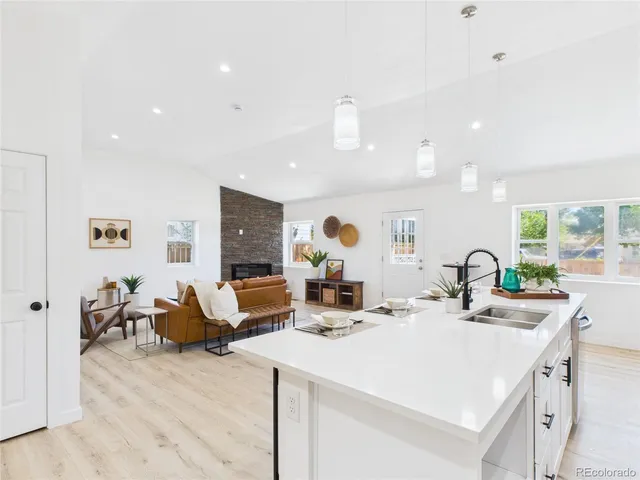 a kitchen with stainless steel appliances a sink stove and wooden floor