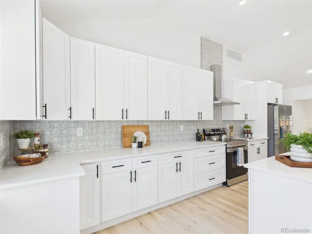 a kitchen with cabinets appliances a sink and a counter top space