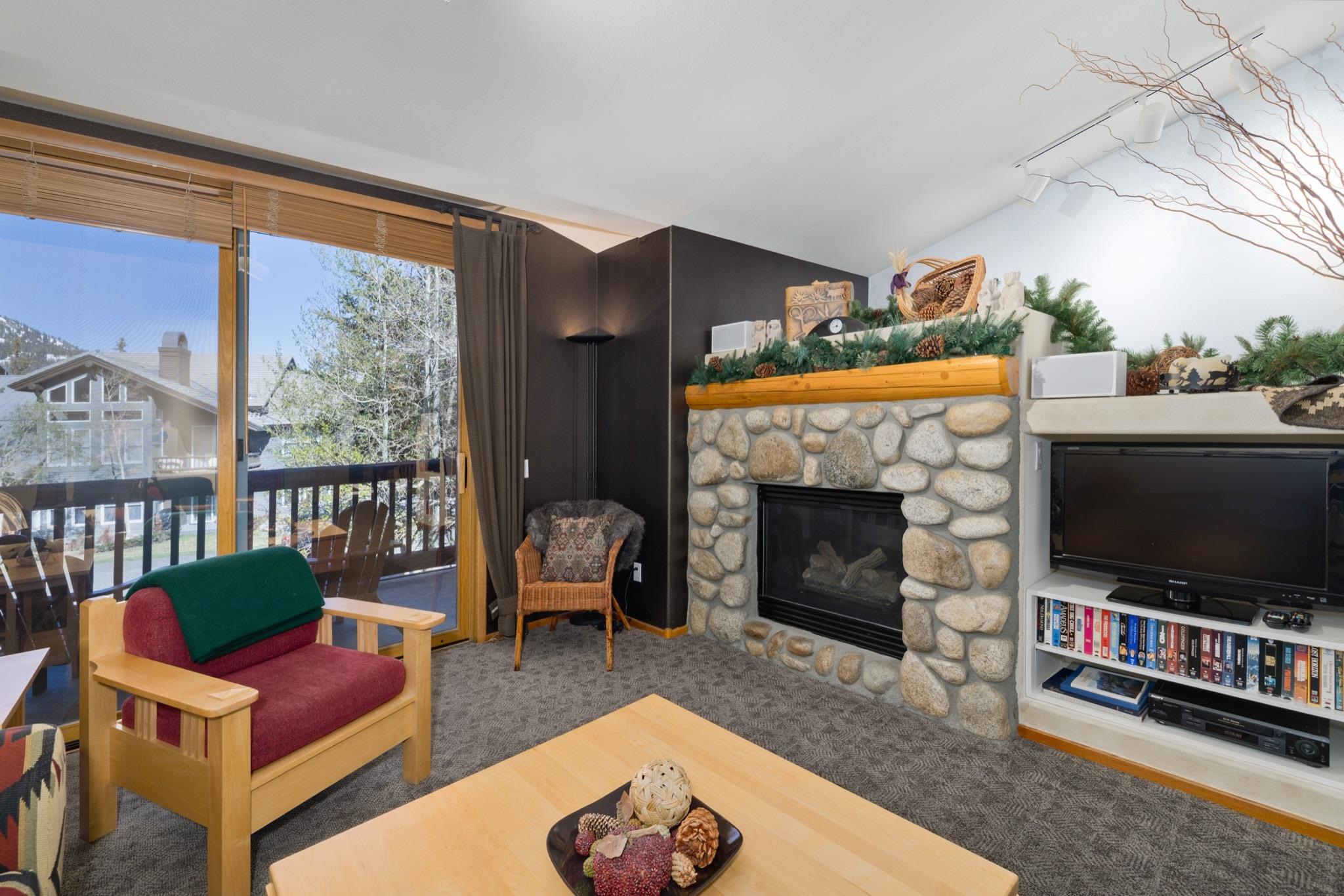 930 Links Way, Unit 930 Mammoth Lakes, CA 93546 - Photo 7 of 40 a living room with furniture a flat screen tv and a fireplace