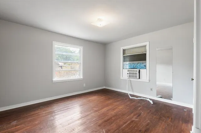 a big room with wooden floor and windows