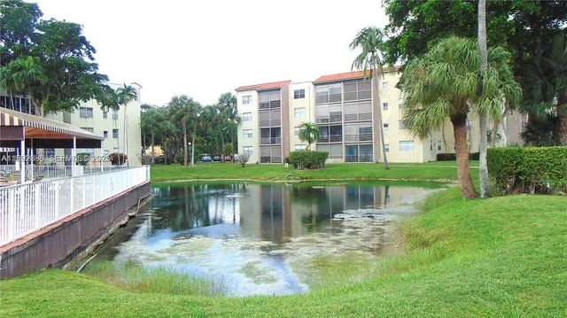 a view of a house with a yard and a fountain