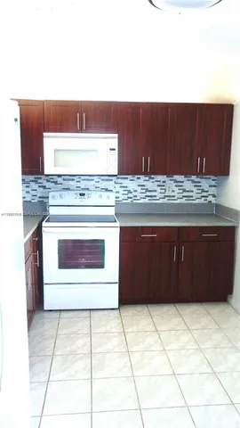 a kitchen with a stove top oven and cabinets