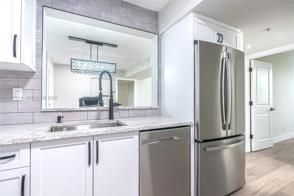 a kitchen with stainless steel appliances granite countertop a refrigerator and a sink