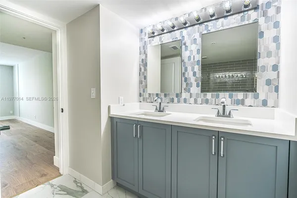 an empty room with wooden floor ceiling fan and windows