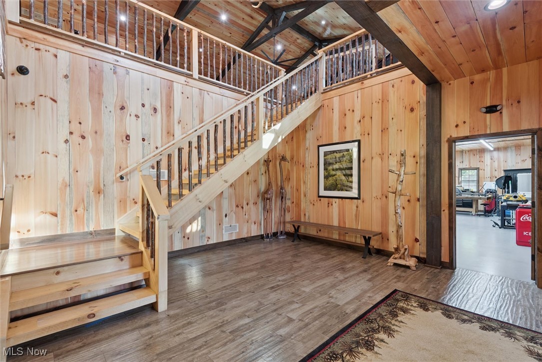 290 Townline Road Aurora, OH 44202 - Photo 7 of 50 Stairs featuring a towering ceiling, wooden walls, wood finished floors, a wood ceiling with exposed beams, and recessed lighting
