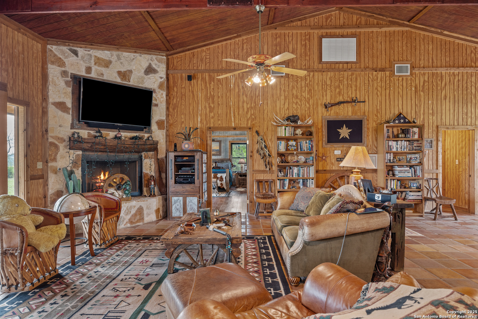 1897 Kyle Ranch Road Bandera, TX 78003 - Photo 3 of 48 a living room with furniture a flat screen tv and a fireplace