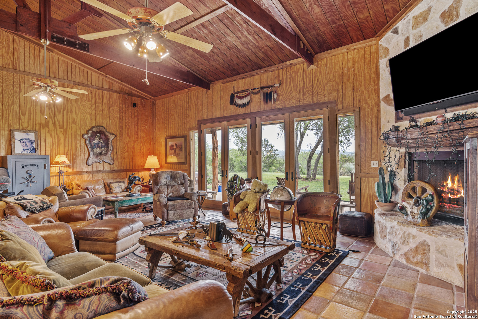 1897 Kyle Ranch Road Bandera, TX 78003 - Photo 4 of 48 a living room with furniture a flat screen tv and a floor to ceiling window