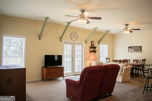 a living room with furniture a flat screen tv and a window