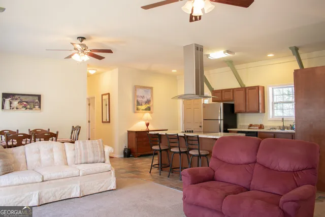 a living room with furniture kitchen view and a chandelier