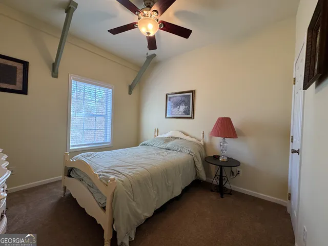 a bed room with a bed and a ceiling fan