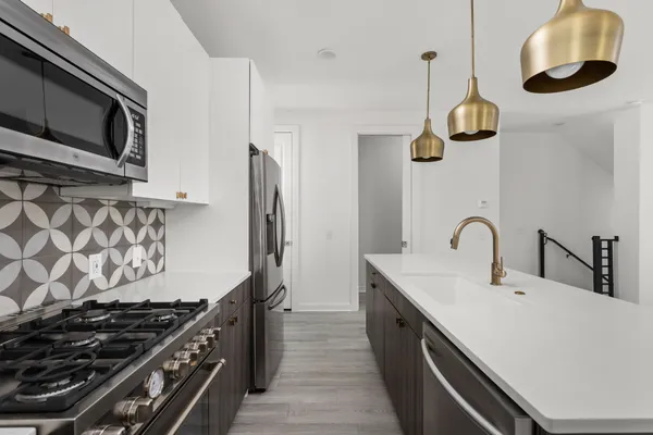 a kitchen with a sink a stove and chairs