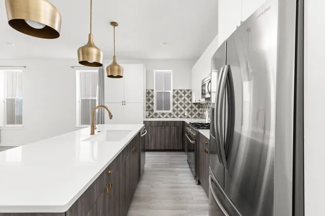 a kitchen with a sink a stove and chairs