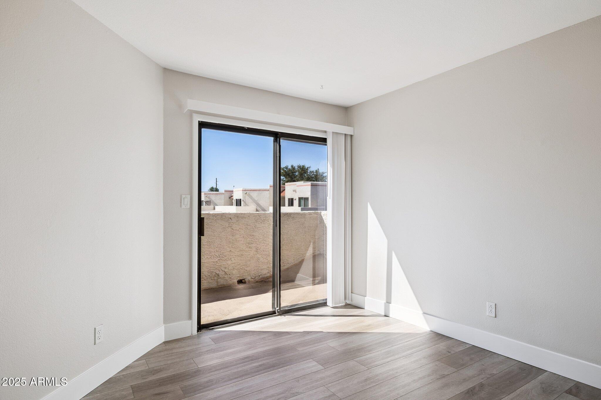 935 North Granite Reef Road, Unit 100 Scottsdale, AZ 85257 - Photo 19 of 35 an empty room with wooden floor and mirror
