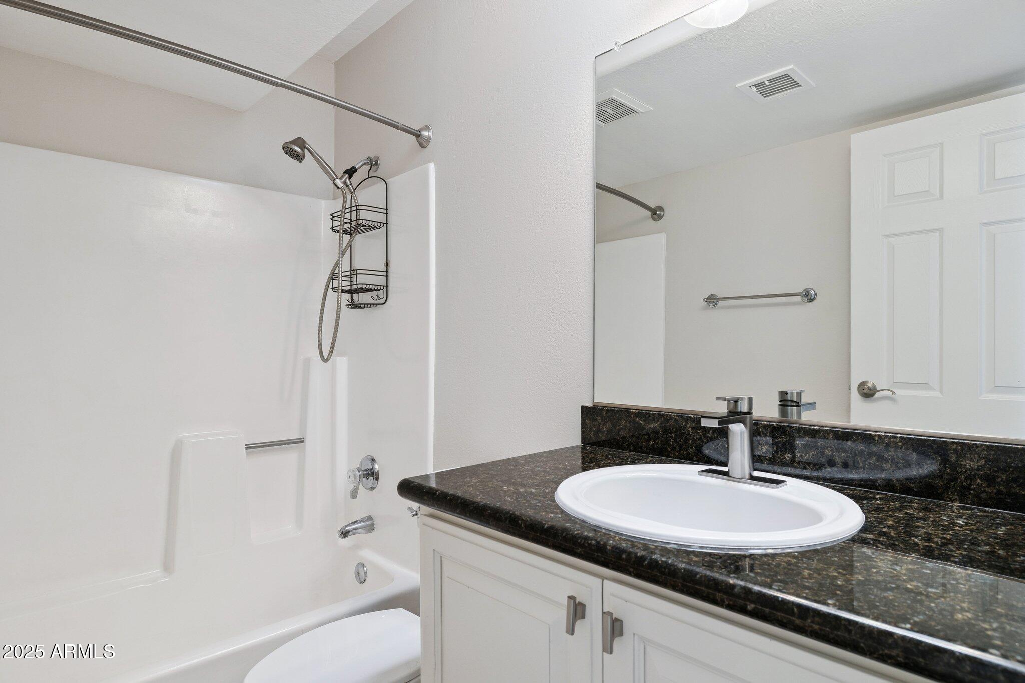 935 North Granite Reef Road, Unit 100 Scottsdale, AZ 85257 - Photo 21 of 35 a bathroom with a granite countertop sink a toilet and shower