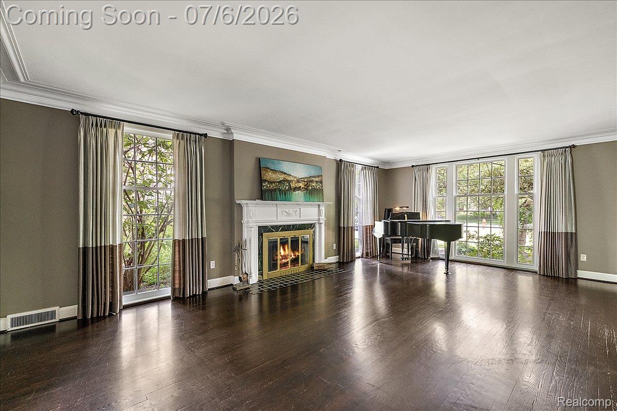 1051 Devonshire Road Grosse Pointe, MI 48230 - Photo 18 of 98 Spacious room featuring dark wood-finish flooring, a white mantel fireplace with a dark surround, and large multi-pane windows
