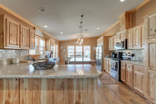 a kitchen with stainless steel appliances granite countertop a stove a sink and a microwave