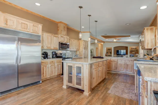 a kitchen with stainless steel appliances granite countertop a stove a sink and a refrigerator