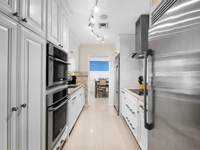 a kitchen with stainless steel appliances a refrigerator sink and cabinets