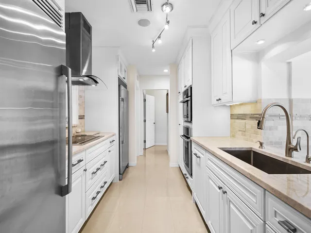 a kitchen with stainless steel appliances a sink and a refrigerator