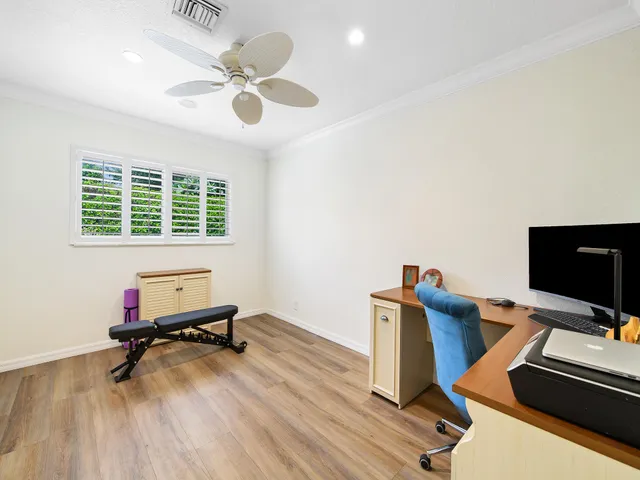 a workspace with furniture hardwood floor and ceiling fan
