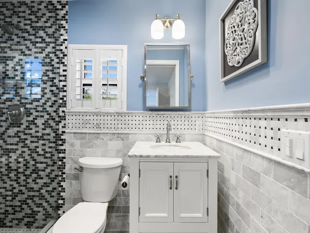 a bathroom with a sink a toilet and a mirror