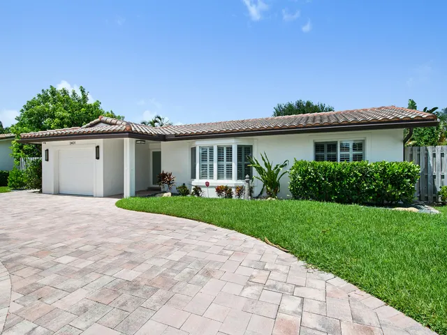 a view of a house with a yard and potted plants
