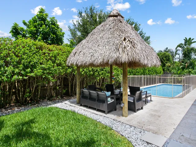 a view of a chair and table in the back yard of the house
