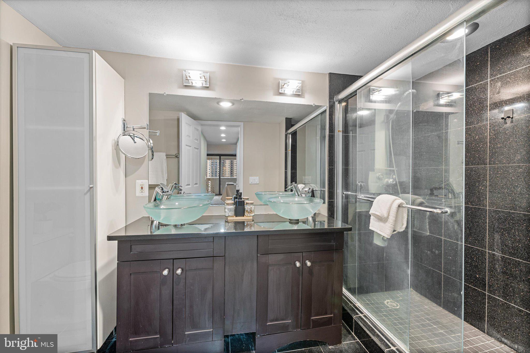 6101 Edsall Road, Unit 1402 Alexandria, VA 22304 - Photo 15 of 37 a bathroom with a granite countertop sink a mirror and a shower