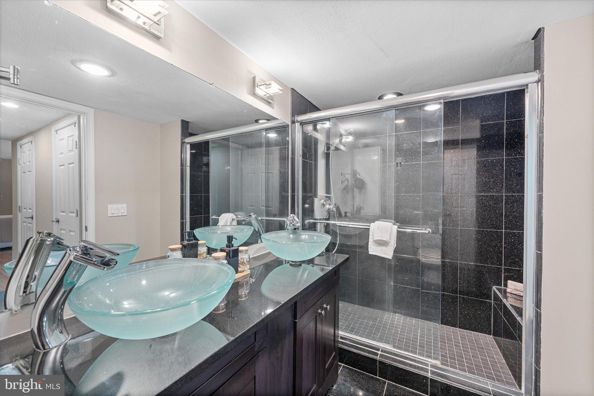 6101 Edsall Road, Unit 1402 Alexandria, VA 22304 - Photo 16 of 37 a bathroom with a granite countertop sink a mirror and a shower