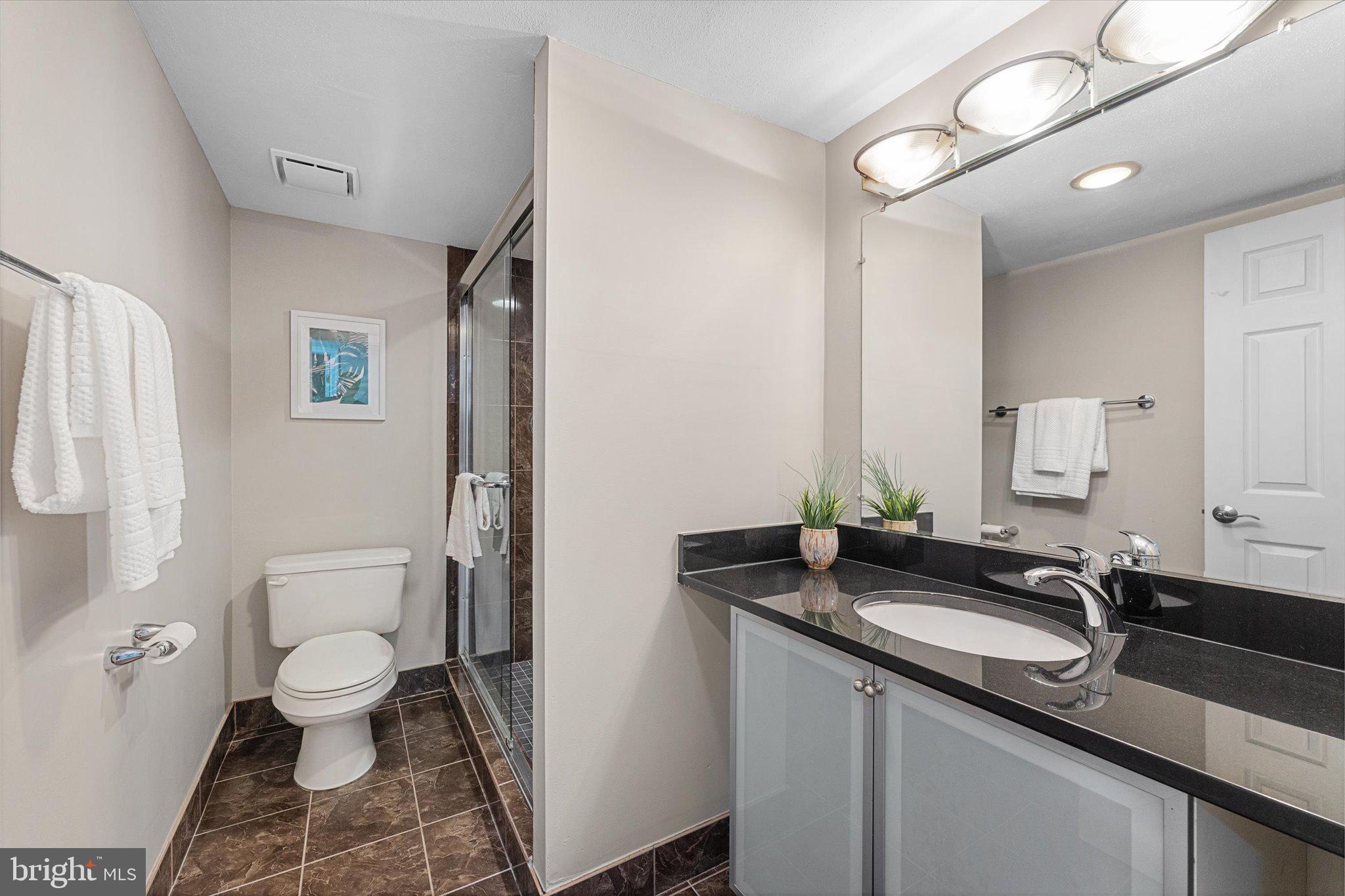 6101 Edsall Road, Unit 1402 Alexandria, VA 22304 - Photo 19 of 37 a bathroom with a sink a toilet and a mirror