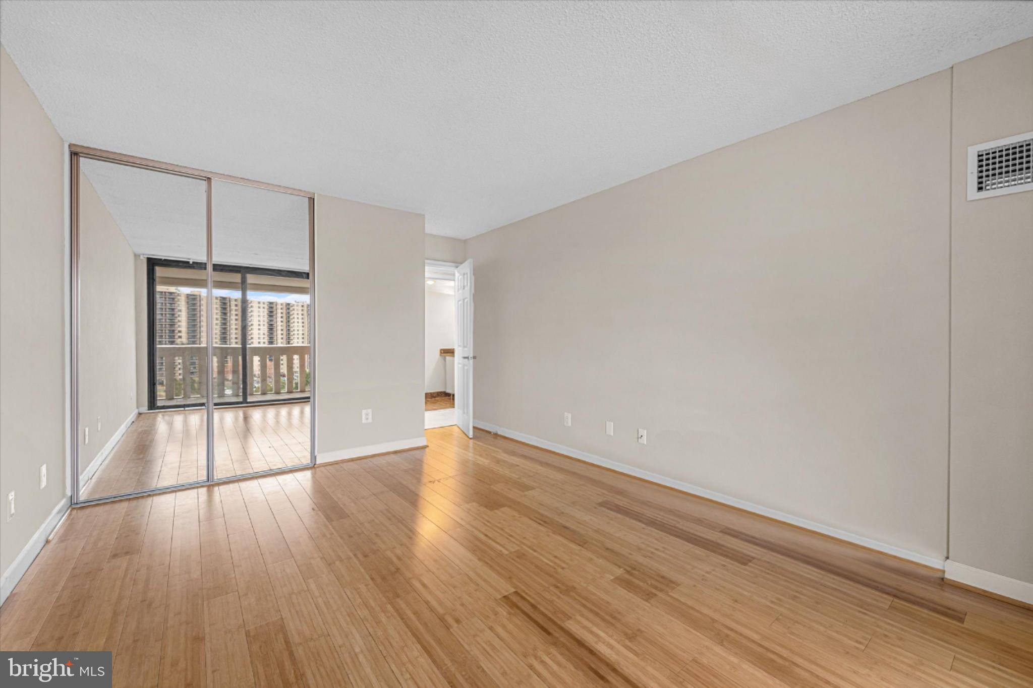 6101 Edsall Road, Unit 1402 Alexandria, VA 22304 - Photo 22 of 37 a view of an empty room with wooden floor and a window