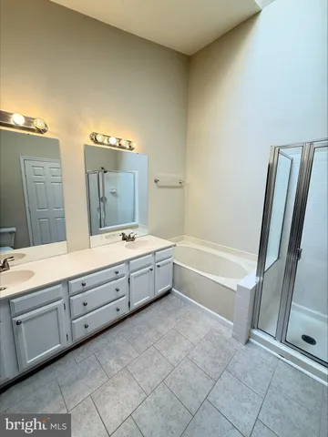 a spacious bathroom with a tub sink and mirror